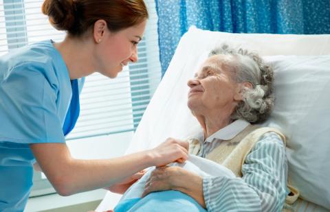 Auxiliar de enfermería cuidando señora con diabetes en el hospital