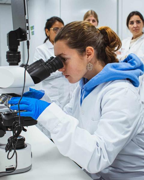 Alumna de anatomía realiza una investigación con un microscopio