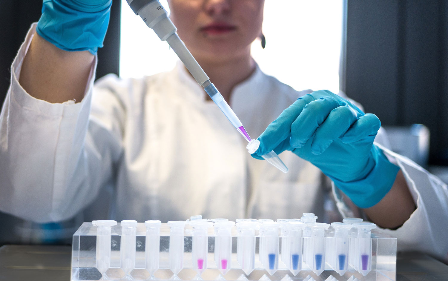 Técnica especialista trabajando con un microscopio en un laboratorio.