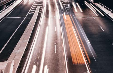 Una carretera iluminada por vehículos en movimiento. Comercio Internacional.