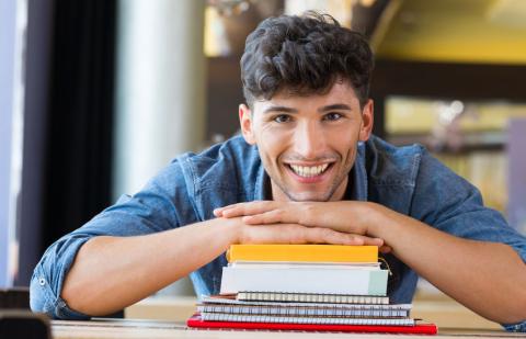 Estudiante de grado superior con libros en la biblioteca.