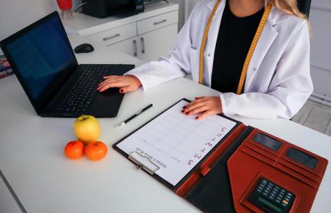 Nutricionista preparando un calendario de alimentación a sus pacientes