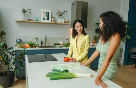 Dos mujeres en la cocina hablando sobre hábitos saludables