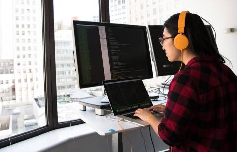 Mujer trabajando con ordenadores con programas de ciberseguridad de los datos personales