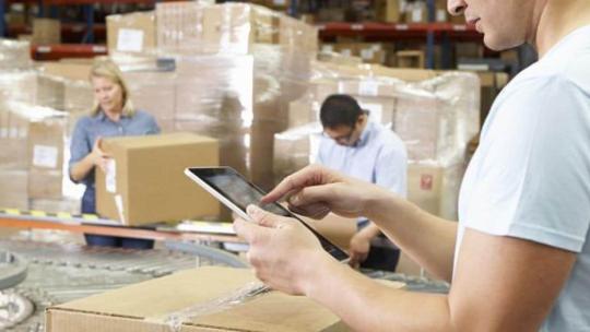 Hombre trabajando con una tablet en un almacén