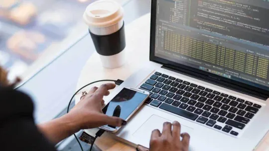 Mujer desarrollando una aplicación multiplataforma en el ordenador