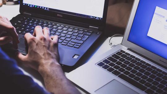 Administrador de sistemas trabajando con dos ordenadores