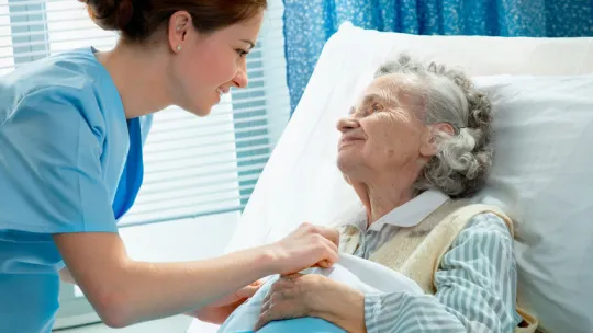 Auxiliar de enfermería cuidando señora con diabetes en el hospital