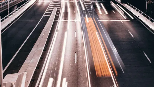 Una carretera iluminada por vehículos en movimiento. Comercio Internacional.