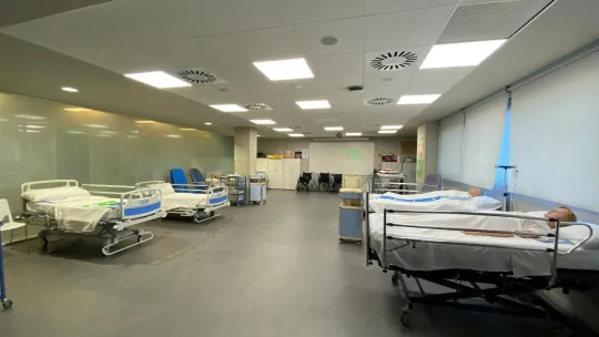 Sala de cuidados de enfermeria en un hospital con camas y personas tumbadas