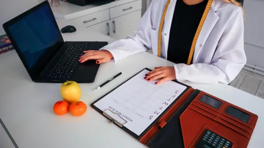 Nutricionista preparando un calendario de alimentación a sus pacientes
