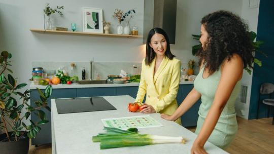 Dos mujeres en la cocina hablando sobre hábitos saludables