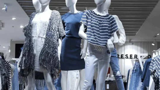 Un escaparate demuestra su buena colocación, organización y coherencia con maniquíes vestidos de azul y con estilo.