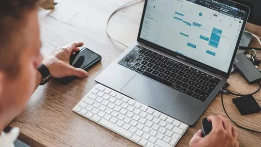 Hombre organiza sus tareas de su programa de estudios en su agenda digital.