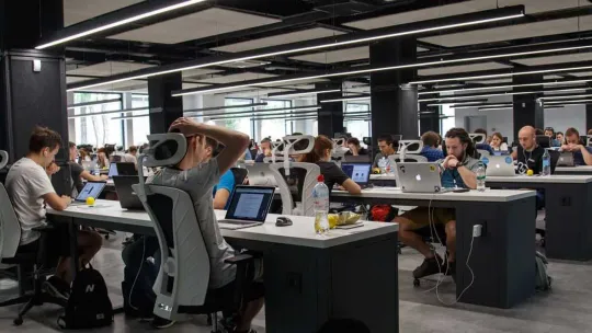 Alumnos estudiando una FP Dual en una oficina diáfana. 