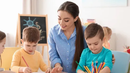 Profesora pintando con sus alumnos escolares en clase