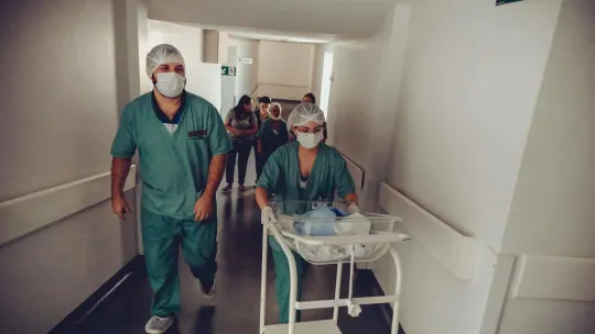 Enfermera Y Obstetra Irreconocible Con Carrito De Bebé Recién Nacido En El Hospital