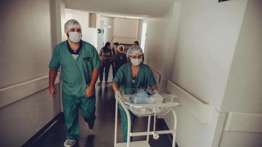 Enfermera Y Obstetra Irreconocible Con Carrito De Bebé Recién Nacido En El Hospital