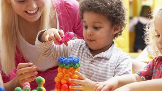 Maestra y niño jugando 
