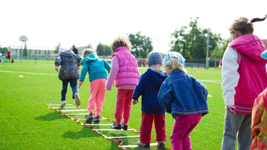 Niños jugando al aire libre, divirtiéndose y haciendo actividad física.