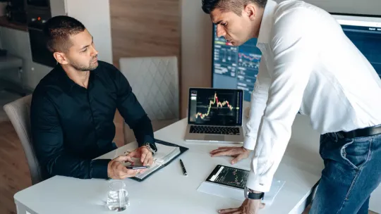 Dos hombres compran y venden acciones en el mercado bursátil. 