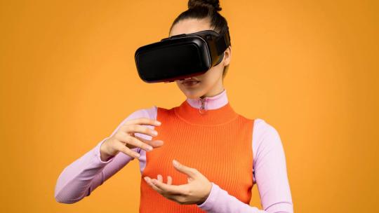 Una mujer con gafas de realidad virtual interactúa en el metaverso.