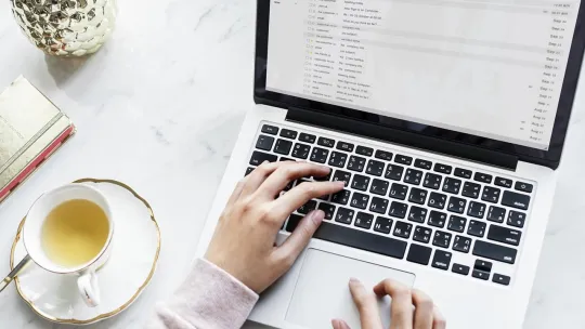 Trabajador en oficina planifica su rutina con un portátil