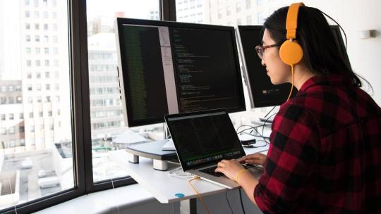 Mujer trabajando con ordenadores con programas de ciberseguridad de los datos personales
