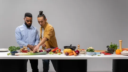 Dos hombres en una cocina con alimentos saludables