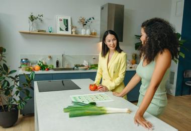 Dos mujeres en la cocina hablando sobre hábitos saludables
