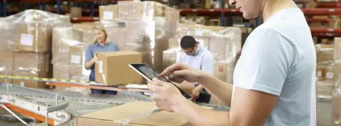 Hombre trabajando con una tablet en un almacén