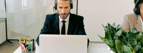 Chico hablando por teléfono con ordenador
