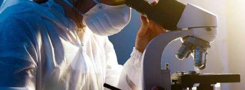 Hombre trabajando con un microscopio en un laboratorio químico