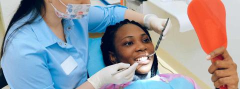 Dentista enseña a su paciente la endodoncia que ha hecho en sus dientes.