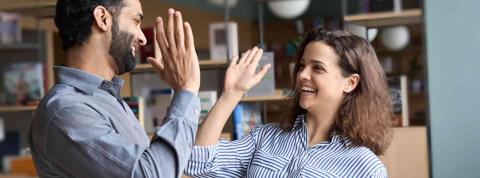 Dos compañeros de trabajo celebran su éxito en administración y finanzas