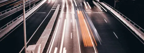 Una carretera iluminada por vehículos en movimiento. Comercio Internacional.