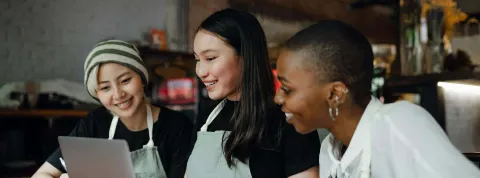 Tres panaderas con un portátil. Sus características demográficas las convierten en un tipo de buyer persona particular. 