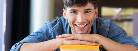 Estudiante de grado superior con libros en la biblioteca.