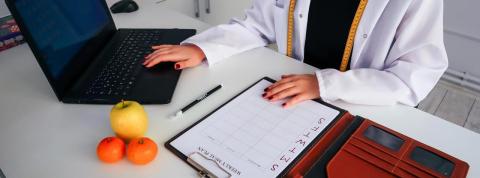 Nutricionista preparando un calendario de alimentación a sus pacientes