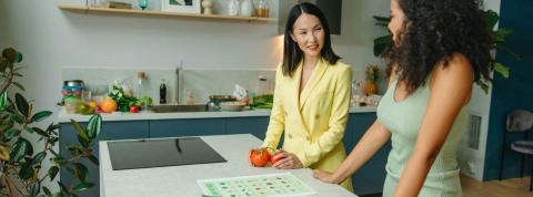 Dos mujeres en la cocina hablando sobre hábitos saludables