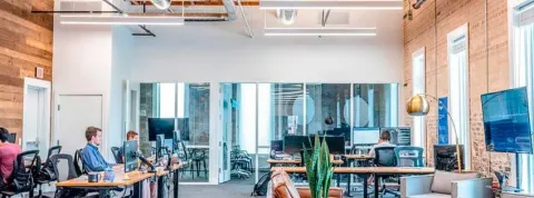 Técnicos de gestión administrativa trabajan en una oficina diáfana.