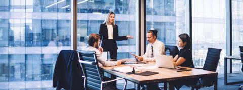 Equipo de Administración y Finanzas discute proyecto en una oficina. 