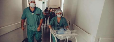 Enfermera Y Obstetra Irreconocible Con Carrito De Bebé Recién Nacido En El Hospital