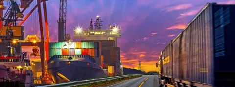 Puerto marítimo al lado de una carretera con transporte terrestre representan subsistemas logísticos.