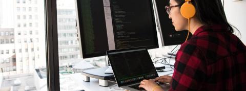 Mujer trabajando con ordenadores con programas de ciberseguridad de los datos personales