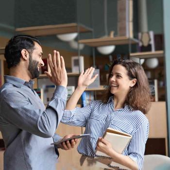 Dos compañeros de trabajo celebran su éxito en administración y finanzas