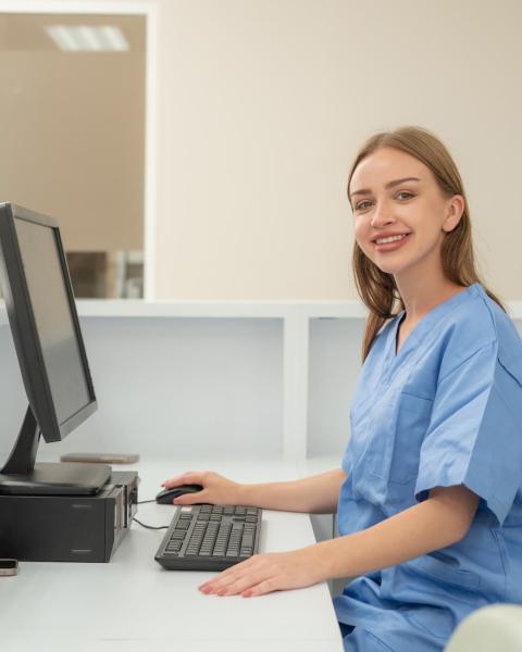 Mujer en su mesa de trabajo, trabaja con ordenador en administración sanitaria