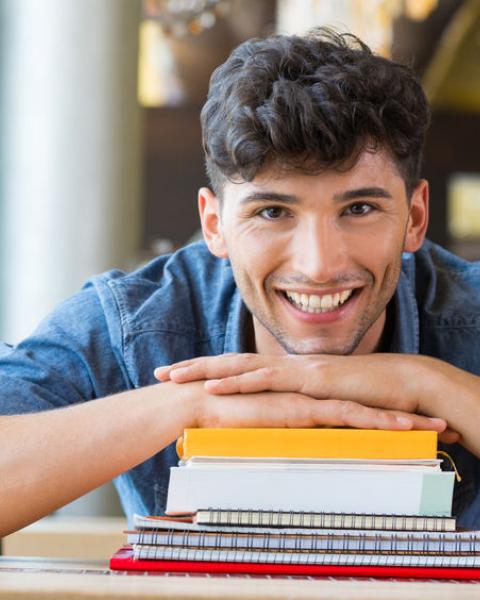 Estudiante de grado superior con libros en la biblioteca.