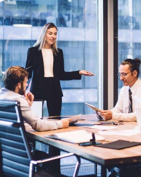 Equipo de Administración y Finanzas discute proyecto en una oficina.