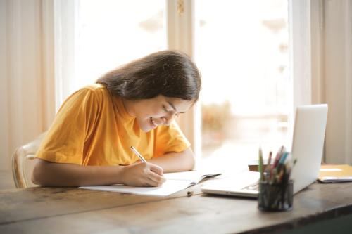 Una mujer joven sonríe mientas estudia una FP